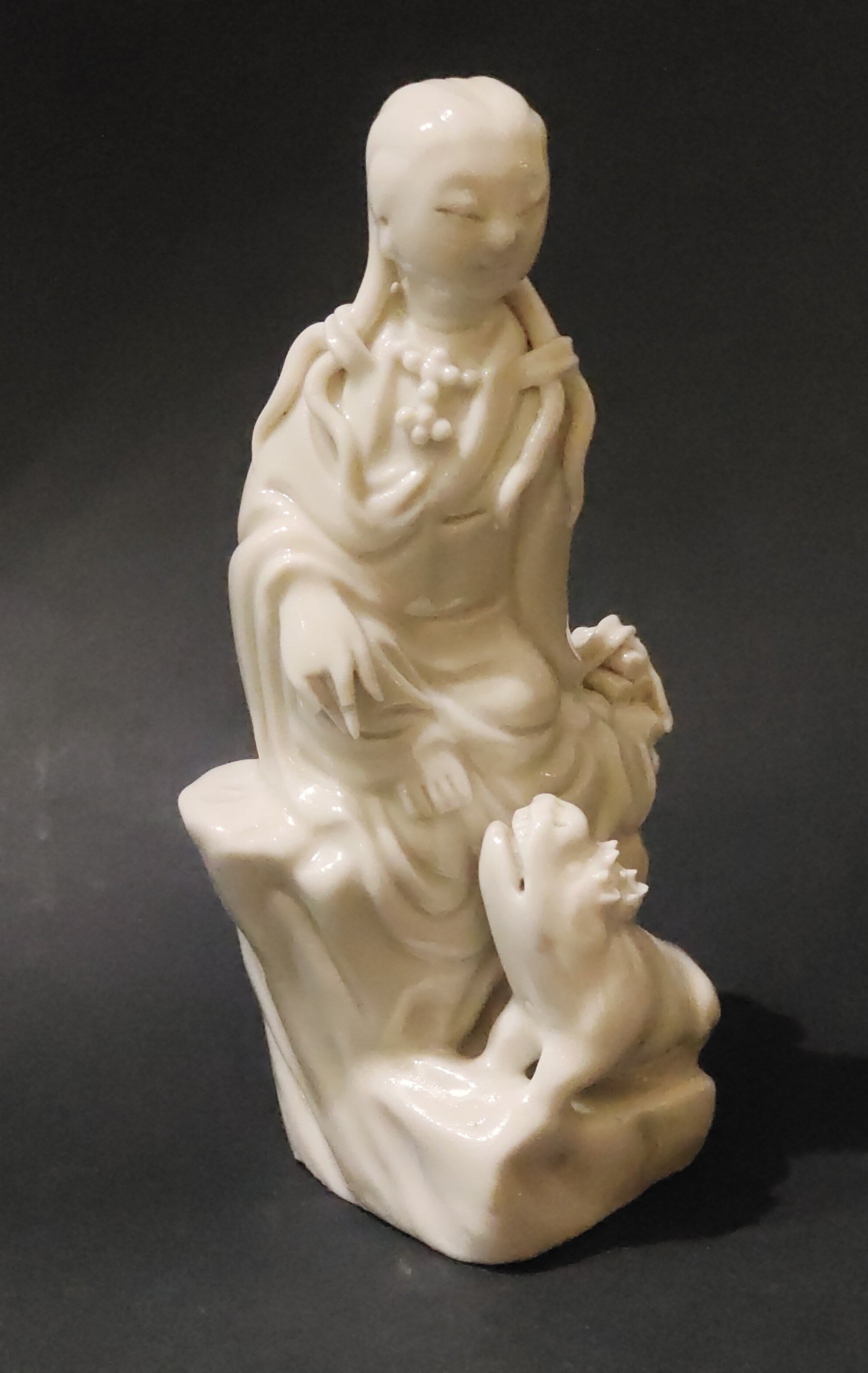 small figure of Guanyin sitting in front of a Fo dog or Buddhist lion made of China blanc de Chine  porcelain kilns of Dehua province of Fujian - China 18/19em 
Mark in the shape of a colocynth on the back